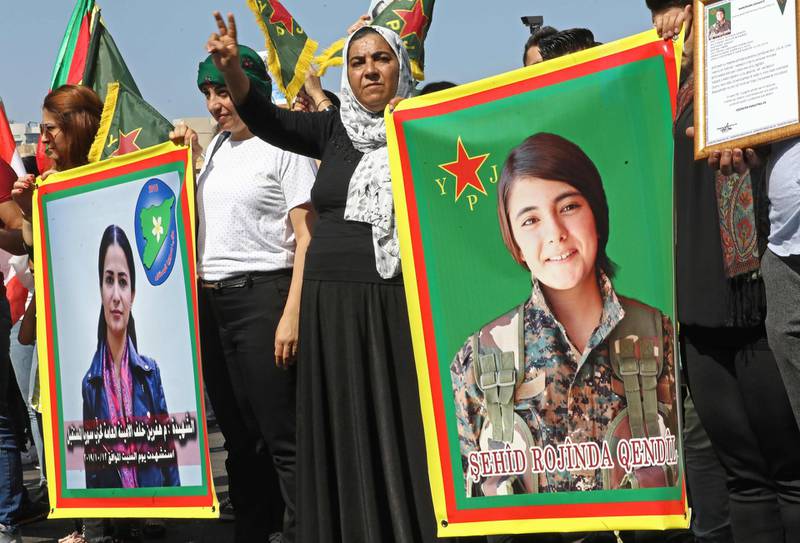 Kurdish protesters wave their national flags and hold photos of Kurdish political leader Hevrin Khalaf (L), who was reportedly killed by Turkish-backed militias, and Sehid Rojinda Qendil, a Kurdish fighter killed in Syria, during a demonstration against the latest Turkish military offensive in northeastern Syria, in central Beirut's Martyrs Square on October 13, 2019.  / AFP / ANWAR AMRO
