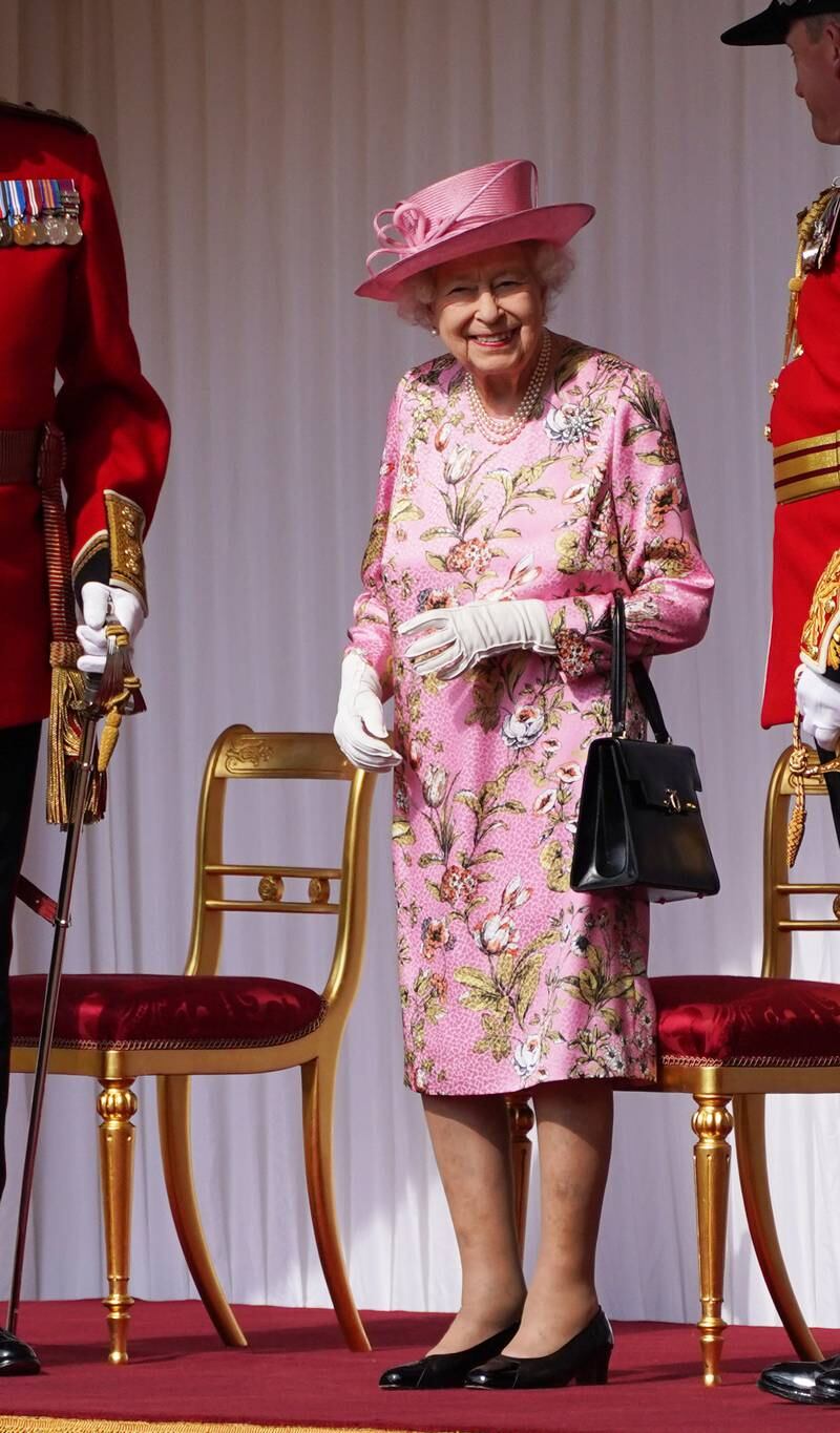 Queen Elizabeth II, wearing pink, waits for the arrival of US President Joe Biden at Windsor Castle on June 13, 2021. Getty Images