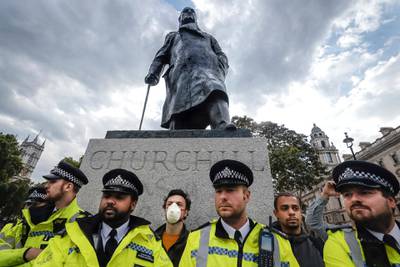 Police officers stand in front of the Winston Churchill statue during a rally in Parliament Square in London. AP Photo