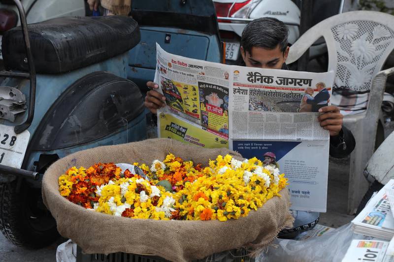 An Indian reads a newspaper with a front page story detailing the US President Donald Trump's state visit to India. EPA