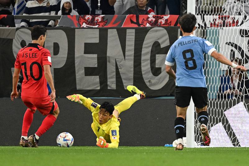 South Korea's goalkeeper Kim Seung-gyu dives to secure the ball. AFP