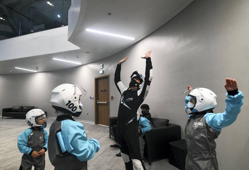 Abu Dhabi, United Arab Emirates - Instructor, Richard Manalaysay teaches the young boys about indoor skydiving before their adventure at CLYMB, Yas Island. Khushnum Bhandari for The National