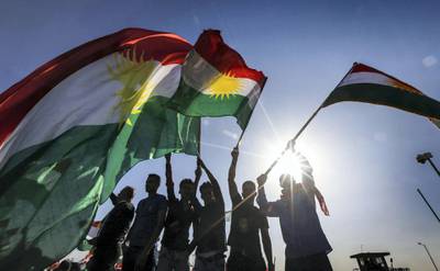 Iraqi Kurds wave flags of Iraqi Kurdistan during a demonstration outside the UN Office in Arbil, the capital of the autonomous region, on October 21, 2017, protesting against the escalating crisis with Baghdad. / AFP PHOTO / SAFIN HAMED