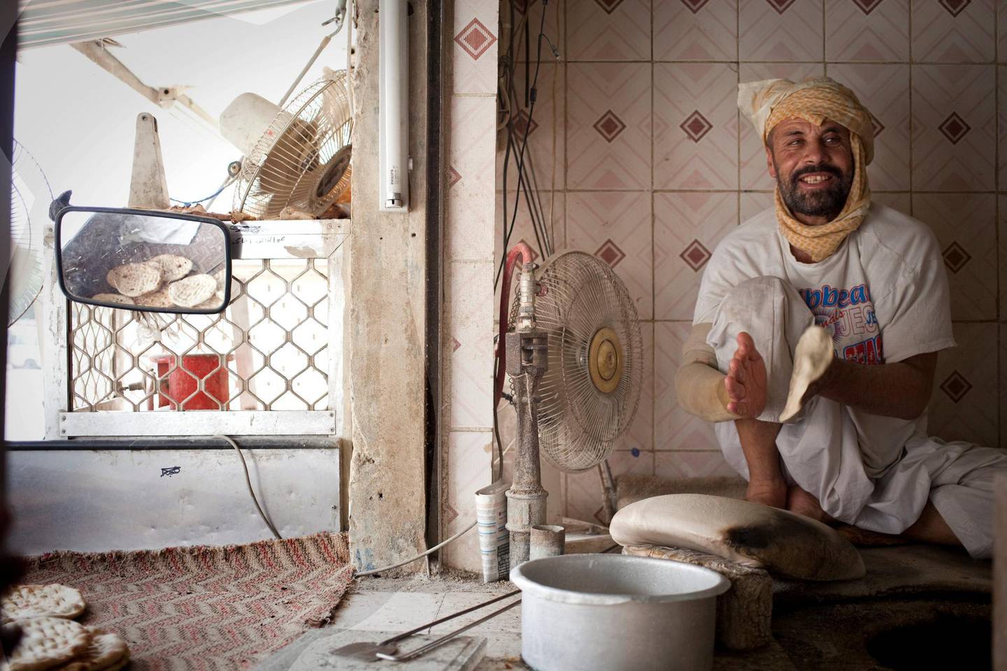 Dubai, United Arab Emirates - August 22 2013 - Sayed Gul,32, bakes Afghani bread at the Ibrahim Al Nubi Ali Bakery in Safa Al Qouz residential area of Dubai for residents of that area. He has been living in the UAE for two years. Tags: STANDALONE (Razan Alzayani / The National) *** Local Caption ***  RA0922_ibrahim_bakery_003.jpg