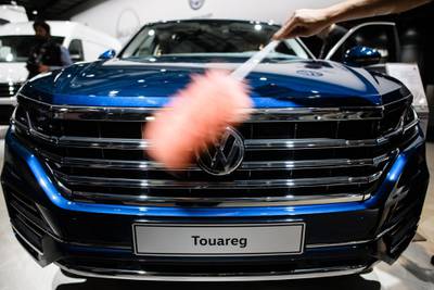 epa06708938 An assistant cleans a VW Touareg SUV car prior to the annual general meeting (AGM) in Berlin, Germany, 03 May 2018. Volkswagen shareholders are gathering for the annual shareholders' meeting, following the Diesel motor manipulation and animal testing scandals.  EPA/CLEMENS BILAN
