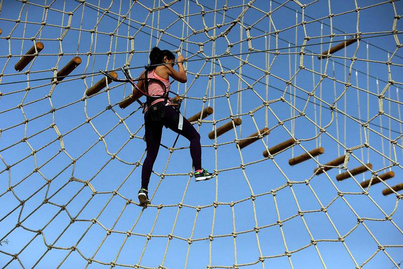 Dubai resident tests out the rope and zipline obstacles at the Aventura nature adventure park, as Mushrif Park in Dubai. Satish Kumar / The National