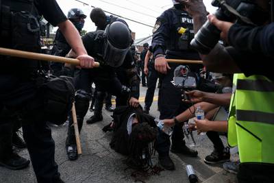 A protestor is detained while bleeding from the head in downtown Louisville, Kentucky, on September 23, 2020, after a judge announced the charges brought by a grand jury against Detective Brett Hankison, one of three police officers involved in the fatal shooting of Breonna Taylor in March. - Hankison was charged today, September 23, with three counts of "wanton endangerment" in connection with the shooting of  Taylor, a 26-year-old black woman whose name has become a rallying cry for the Black Lives Matter movement. (Photo by Jeff Dean / AFP)