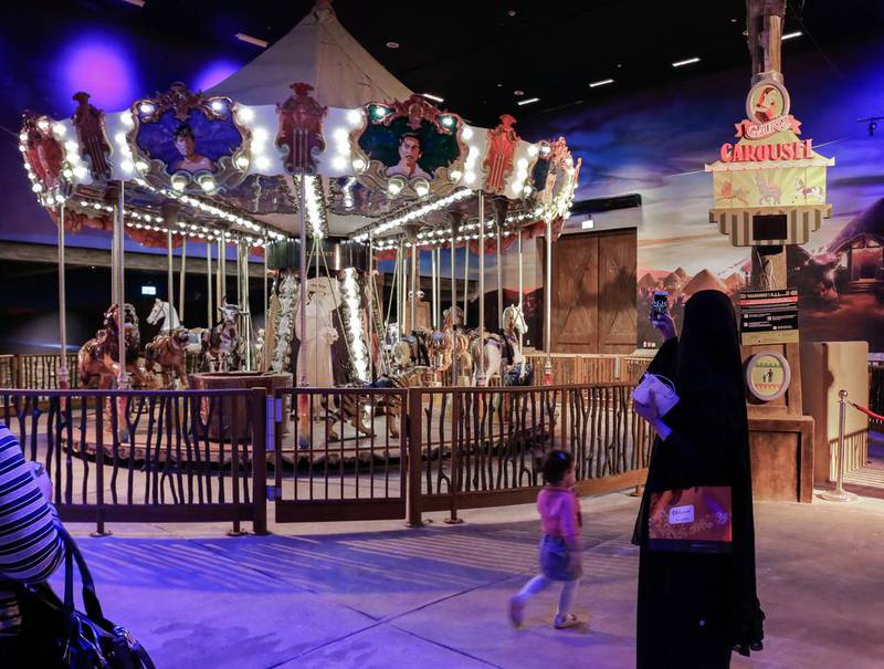 A visitor takes a photo of a carousel roundabout on the opening night of Bollywood Parks Dubai. Victor Besa for The National