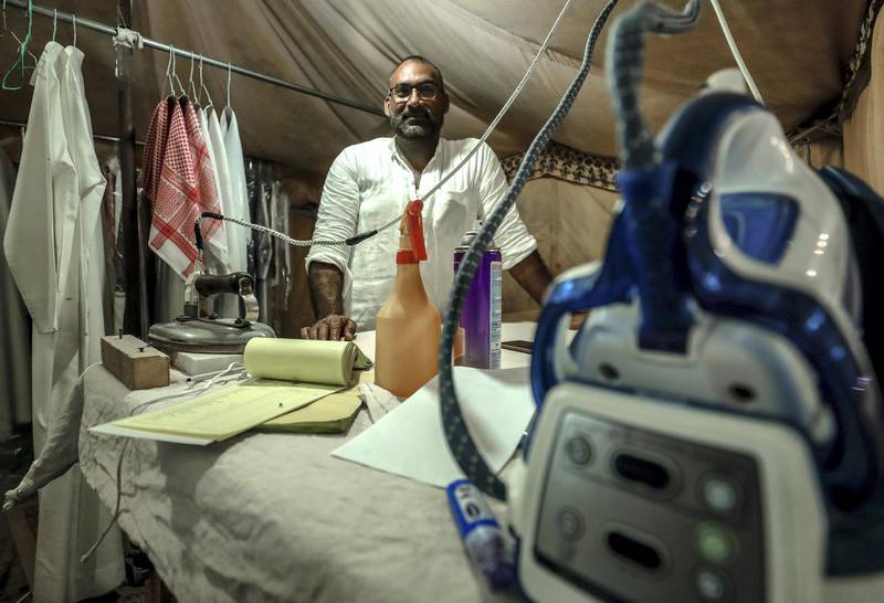 Abu Dhabi, United Arab Emirates, December 10, 2019.    -- Etisham Ahmed presses 50 conduras a day at a tent pop-up of Red Robe Laundry at the Al Dhafra Festival.Victor Besa/The NationalSection:  NAReporter:  Anna Zacharias