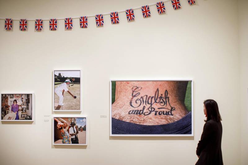 A visitor looks at photographs displayed at the Only Human: Photographs by Martin Parr exhibition during the press preview at National Portrait Gallery in London on March 6, 2019. (Photo by Tolga Akmen / AFP) / RESTRICTED TO EDITORIAL USE - MANDATORY MENTION OF THE ARTIST UPON PUBLICATION - TO ILLUSTRATE THE EVENT AS SPECIFIED IN THE CAPTION