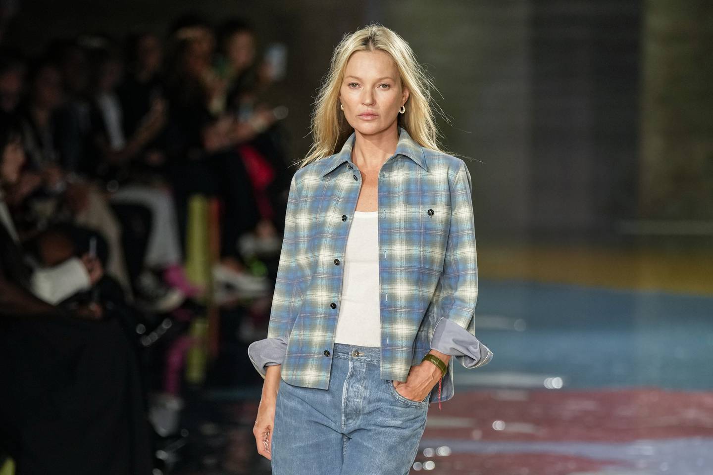Kate Moss in a classic plaid shirt and denim faux leather pants at the Bottega Veneta Women's Spring/Summer 2023 show.  AP photo