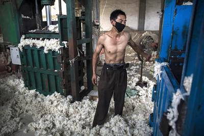 A worker uses a machine to bag sheep’s wool imported from Australia after it was processed and bleached. Kevin Frayer / Getty Images