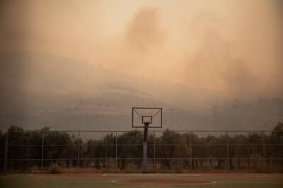 Smoke rising from a wildfire covers the air over a basketball court near Lardos, on the island of Rhodes, Greece. Reuters