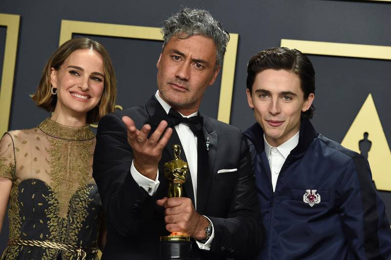 Natalie Portman, from left, Taika Waititi, winner of the award for best adapted screenplay for "Jojo Rabbit", and Timothee Chalamet pose in the press room at the Oscars. AP