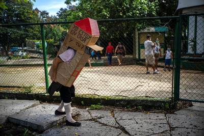 Feridia Rojas, a retired nurse, wears a cardboard box as a protective measure against the spread of the coronavirus, in Havana. AP Photo