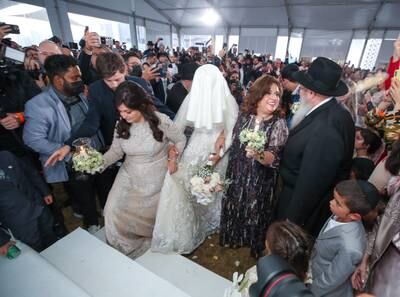 Ms Hadad, centre, is escorted to the chuppah by her mother, Batcheva Hadad, and mother-in-law, Feige Duchman.