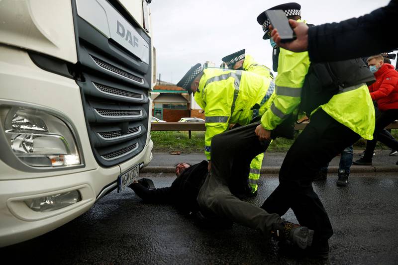 Police officers drag a person lying down in front of a lorry at the Port of Dover, as EU countries impose a travel ban from the UK following the coronavirus disease (COVID-19) outbreak, in Dover, Britain, December 23, 2020. REUTERS/John Sibley TPX IMAGES OF THE DAY