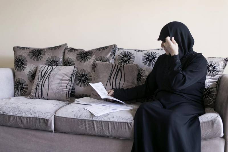 Dalal Alali, 53, looks through her costly medical records. At the hospital where the Syrian expatriate is being treated for bone and breast cancer, doctors say the cost of her chemotherapy will run into tens of thousands of dirhams. Reem Mohammed / The National 