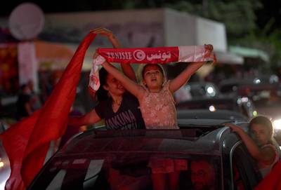 People celebrate on the streets after Tunisian President Kais Saied announced the dissolution of parliament and Prime Minister Hichem Mechichi's government in Tunis on July 25, 2021.