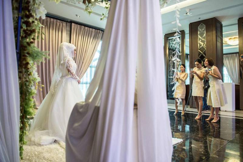 A bride is photographed by friends on her wedding day at the Al Meroz hotel in Bangkok. Thailand has seen an influx of visitors from Muslim countries as part of its strategy to diversify its visitor profile. Roberto Schmidt / AFP Photo