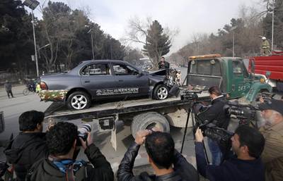 Afghan security officials remove a damaged vehicle from the scene of the suicide bomb attack in Kabul. Hedayatullah Amid / EPA