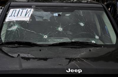 A sign saying 'children' on the windscreen of a car with bullet holes in Irpin on April 19. AFP