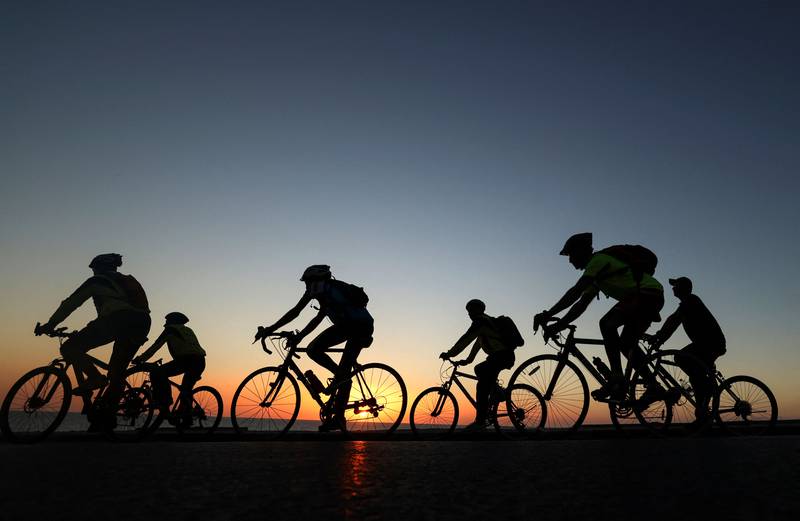 Palestinians ride bicycles at sunset along the shoreline in Gaza City. AFP