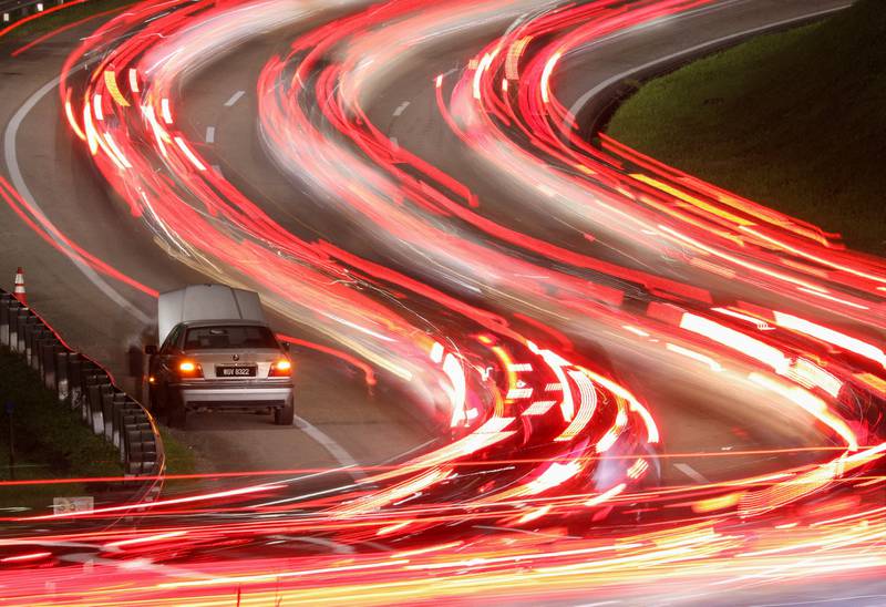 A broken-down car on a motorway as Malaysian Muslims travel home to celebrate Eid Al Fitr, in Gombak, Malaysia, April 29, 2022. Picture taken with long exposure. Reuters