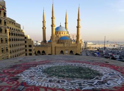 A picture taken on November 5, 2019, shows graffiti on top of the Dome City Center known as "The Egg", next to the Mohammed al-Amin mosque, in downtown Beirut during sunrise. Demonstrators in Lebanon blocked key roads and prevented some public institutions from opening after mass rallies showed political promises had failed to extinguish the unprecedented protest movement. / AFP / Jean Marc MOJON
