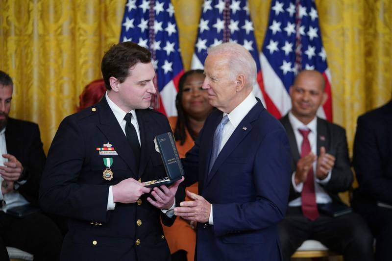 Metropolitan Police Department Officer Daniel Hodges receives his medal. 'To all the families here who lost someone, this country thanks you,' Mr Biden said. AFP