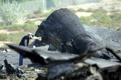 SHARJAH . 22nd October. 2009. SHARJAH AIR CRASH.  A crash investigator inspects the burnt out tail section of the aircraft  yesterday(thurs) Stephen Lock   /   The National    *** Local Caption ***  SL-tail-001.jpg
