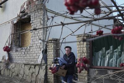 A man removes his belongings from his house after it was struck by artillery shells in Novoluhanske, eastern Ukraine. AP