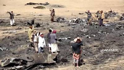 People inspect purported plane crash site in Jawf. Houthi Media Centre via Reuters