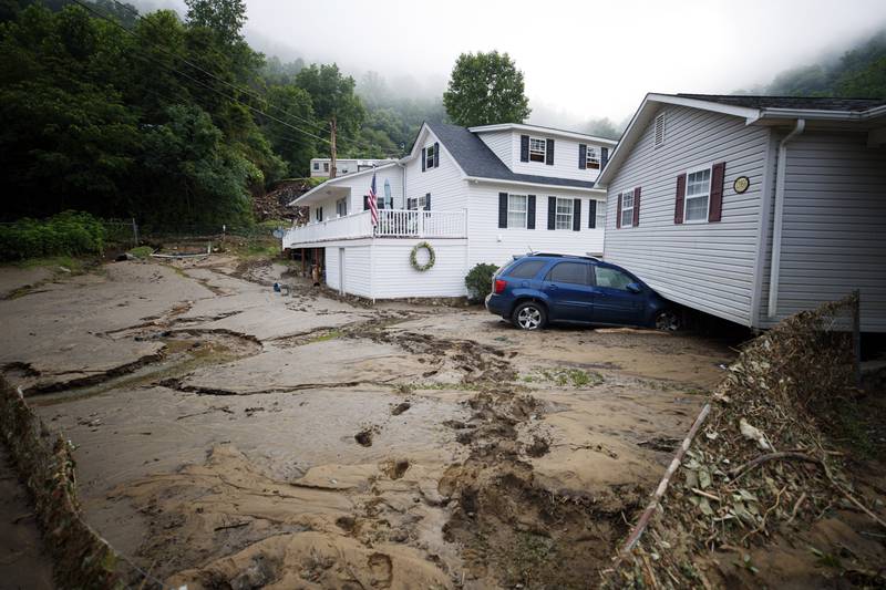 A house that was shifted off its foundation following a flash flood rests on top of a vehicle, on July 14, 2022, in Whitewood, Virginia.  AP Photo