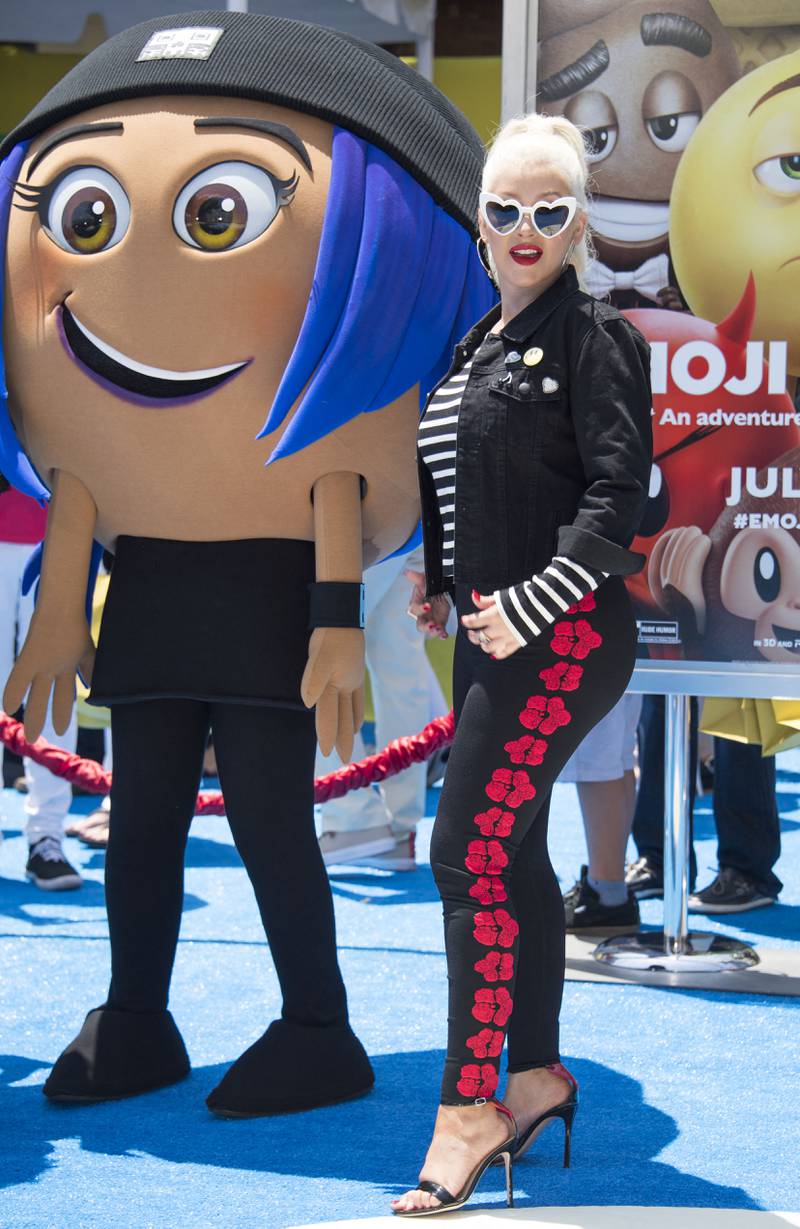 Christina Aguilera, wearing a striped Saint Laurent T-shirt and flower emblazoned trousers with a High Heels Suicide jacket, attends the premiere of 'The Emoji Movie' on July 23, 2017 in California. AFP