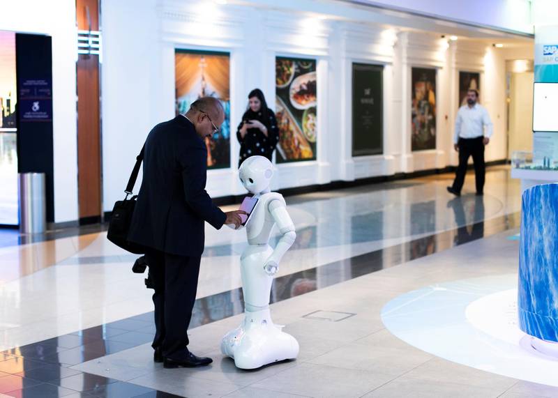 DUBAI, UNITED ARAB EMIRATES. 3 NOVEMBER 2019. A man interacts with Pepper at Emirates NBD branch in Emirates Towers.Dubai Future Foundation (DFF) launched Dubai Future Week which offers a schedule of community events and interactive workshops at AREA 2071 in Emirates Tower, as part of efforts to offer a global futuristic experience that promotes technological knowledge and applications.Under the theme: “Imagining, Designing and Executing the Future”, participants will have the opportunity to preview international films that envision the future, play Human Experience 2.0, an awareness game that introduces futuristic technologies, marvel at the Future Exhibition of images, shopping and the future of food, and engage in Future Dialogues which will explore various sectors such as education, workforce, economics and transportation.(Photo: Reem Mohammed/The National)Reporter:Section: