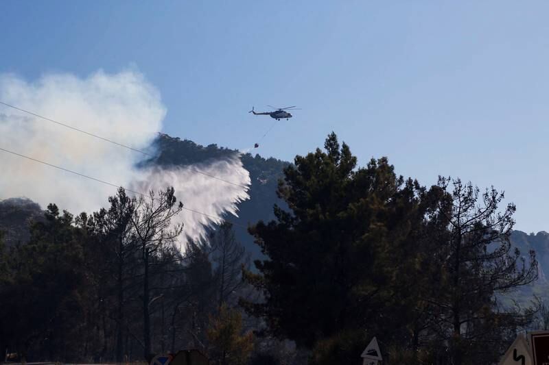 A helicopter drops water to extinguish a wildfire in Datca, Mugla province, south-west Turkey. Reuters