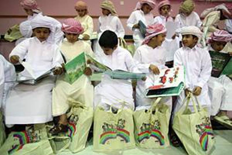 Children from the Al Hamdania Boys School look through books given to them by Kalima.