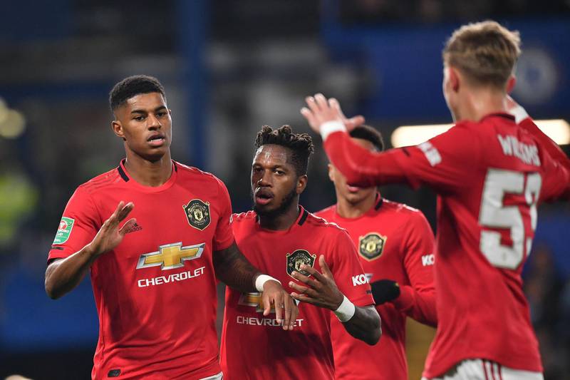 Manchester United's English striker Marcus Rashford, left, celebrates with teammates after scoring his team's first goal. AFP