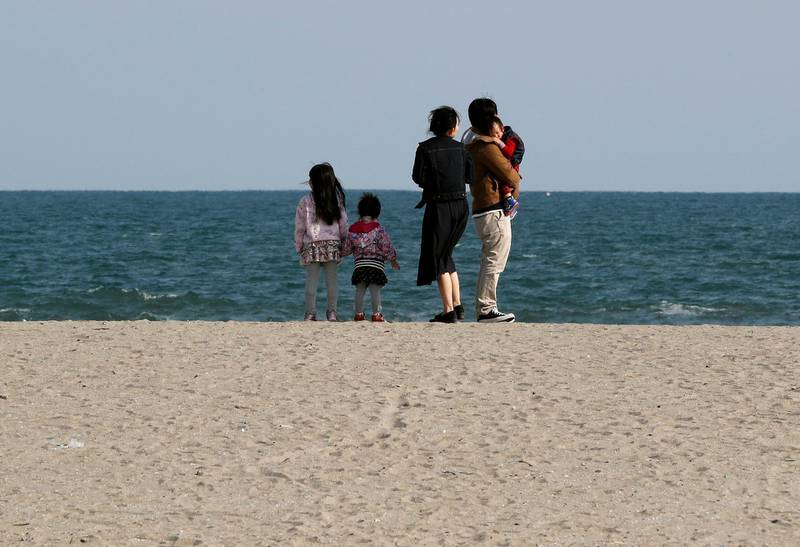 A family takes a moment as they visit Arahama Beach in Sendai, Miyagi Prefecture, Japan, on March 11, 2018. Kimimasa Mayama / EPA