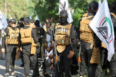 Members of the Hashed al-Shaabi, or Popular Mobilisation Forces (PMF), paramilitaries stand guard during a funerary procession for Wissam Alyawi, a leading commander of the Asaib Ahl Al-Haq faction that is part of the PMF, in the Iraqi capital Baghdad. The headquarters of Asaib Ahl Al-Haq in Iraq's southeastern Missan province was torched on October 25, with the group's leading commander and his brother killed, after being stormed by protesters. Alyawi was pronounced dead by the group after footage circulated online showing him writhing in an ambulance as a crowd of men tried to break into it. AFP