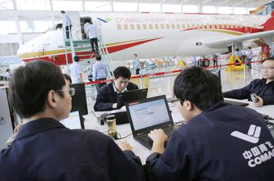 Technicians work on their computers at the Comac factory in Shanghai. China launched the ARJ21 project in 2002 in an attempt to break into the Western-dominated aircraft market. Carlos Barria / Reuters