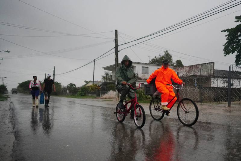 A ride in the rain in Coloma, Cuba. Reuters