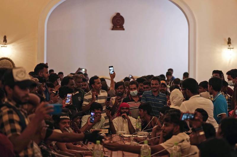 Protesters pretend to hold a Cabinet meeting in the meeting hall of the president's official residence. AP