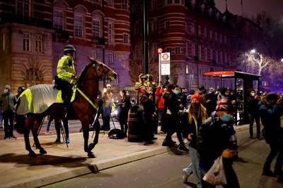 A mounted police officer tries to disperse people on The Victoria Embankment as groups of revellers gather in a near-deserted London late on New Year's Eve. AFP