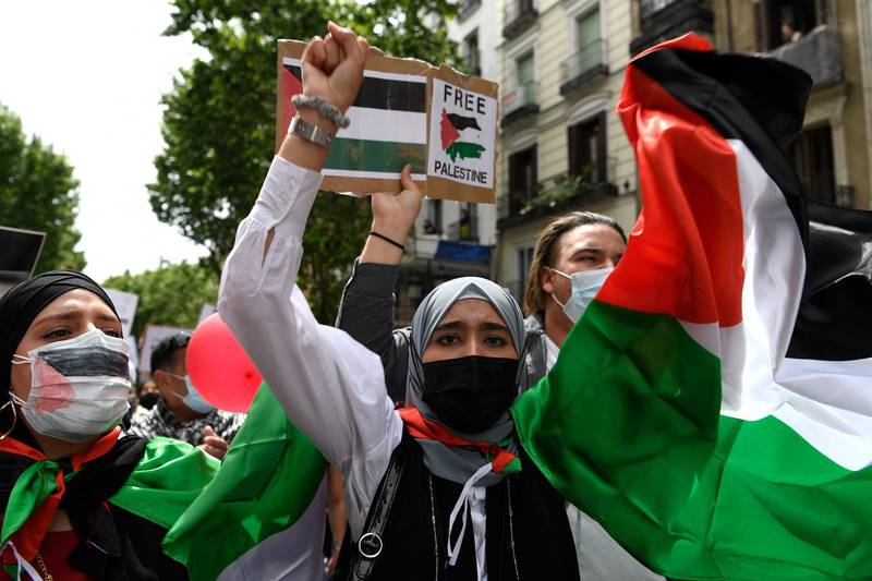 People wave Palestinian flags during a demonstration marking the 73rd anniversary of the Nakba in Madrid. AFP