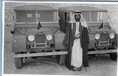 Sheikh Shakhbut with two of his Land Rovers at Qasr Al Hosn in 1956. Courtesy of the estate of Roderick Owen