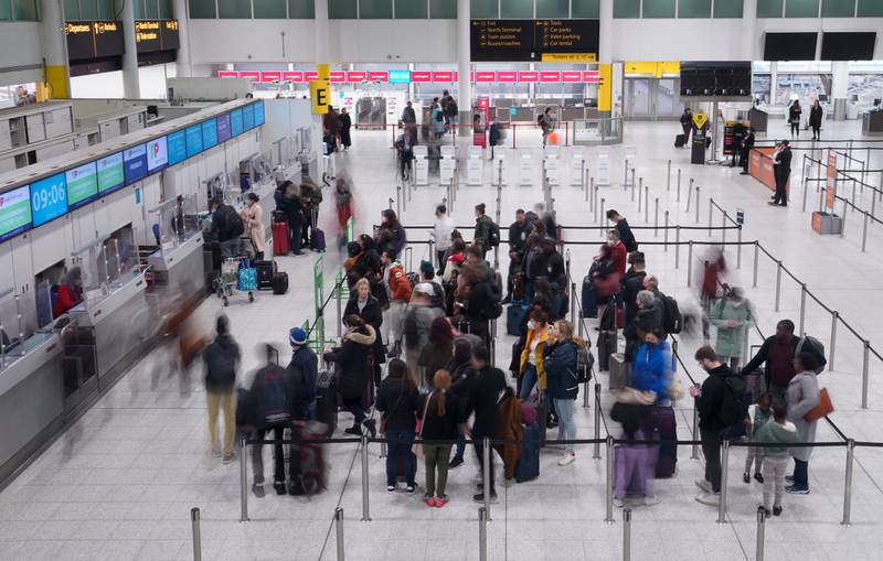 Passengers check in at the South Terminal of London Gatwick Airport in West Sussex. PA