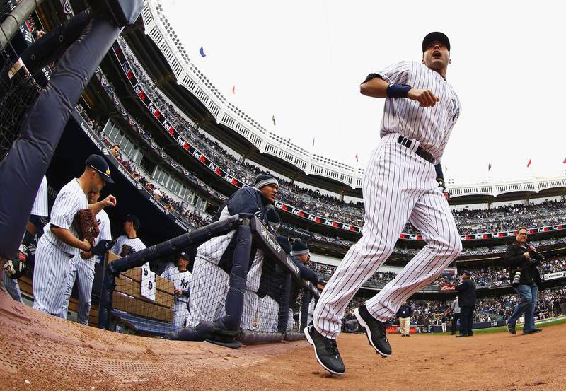 Derek Jeter, right, of the New York Yankees leads his team on to the field for his final home opener against the Baltimore Orioles at Yankee Stadium in the Bronx borough of New York City. Al Bello / Getty Images / AFP