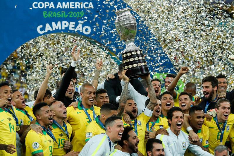 Brazil's Dani Alves lifts up the trophy as Brazil celebrate their success. AP Photo